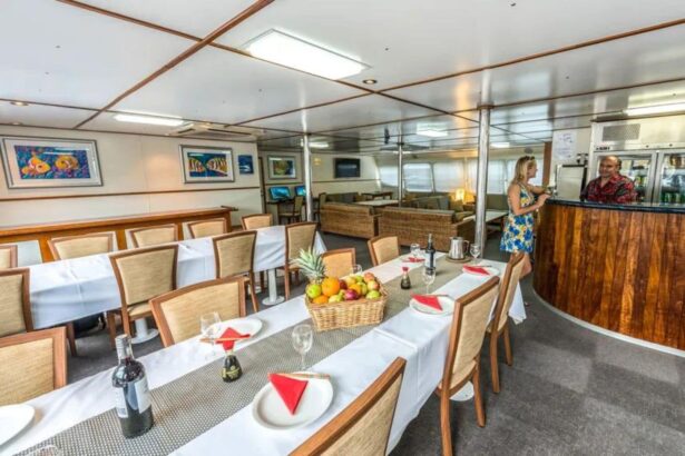 Dining room aboard the Spoilsport set with white tablecloths and a fruit basket
