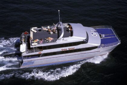 Aerial view of the Spoilsport liveaboard catamaran with guests relaxing on its sun deck