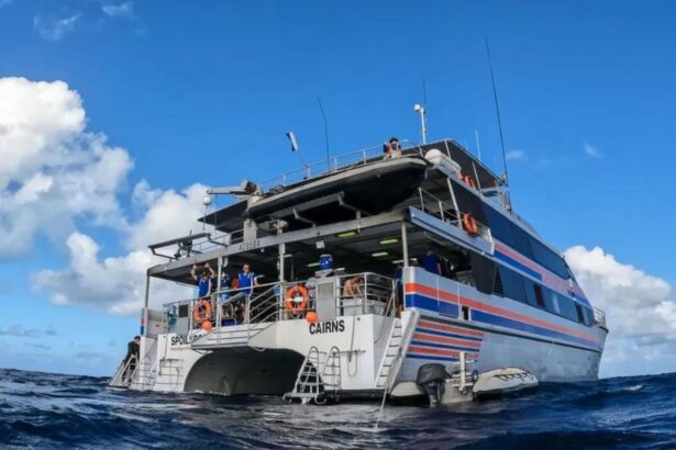 The Spoilsport liveaboard underway at sea with crew waving from the deck