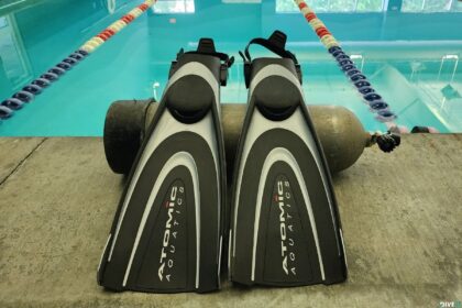 Atomic Aquatics BladeFin fins standing on the pool deck in front of a scuba tank during DIVEIN testing