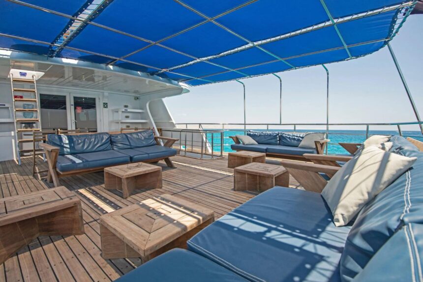 Salon lounge aboard the Blue Horizon with grey sofas and wood coffee tables