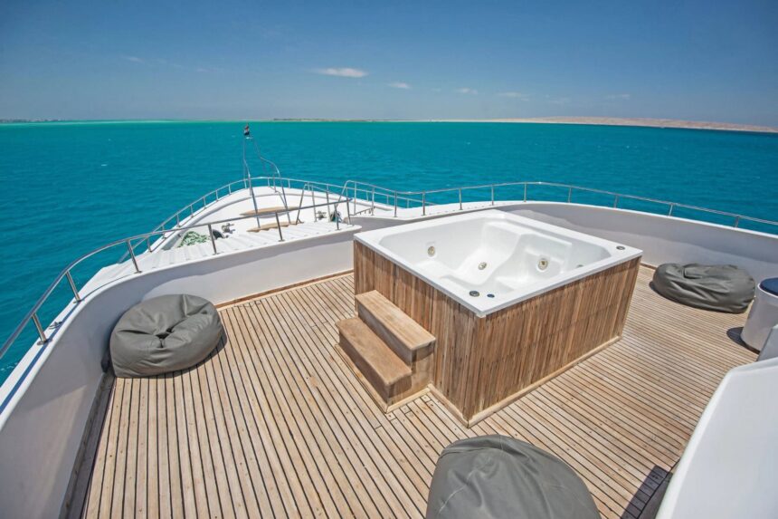 Shaded aft deck of the Blue Horizon with lounge seating and folding wooden tables