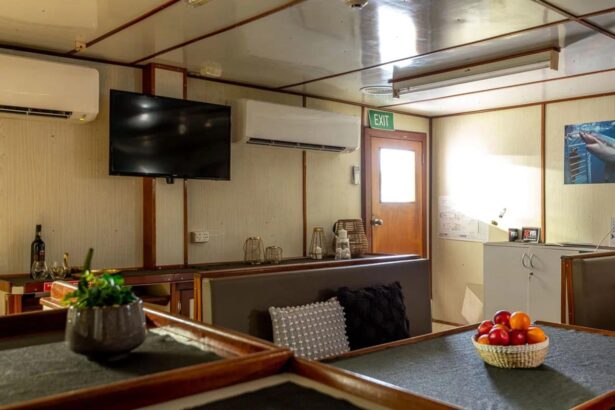 Lounge area aboard the MV Rodney Fox with a wall-mounted TV, bar counter and fruit bowl