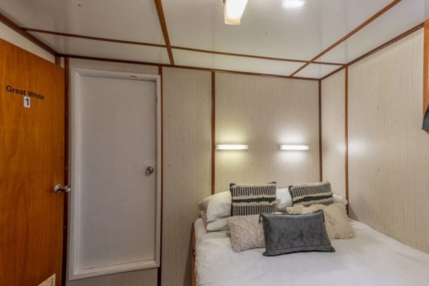 Great White 1 cabin aboard the MV Rodney Fox with a made-up bed and ensuite door