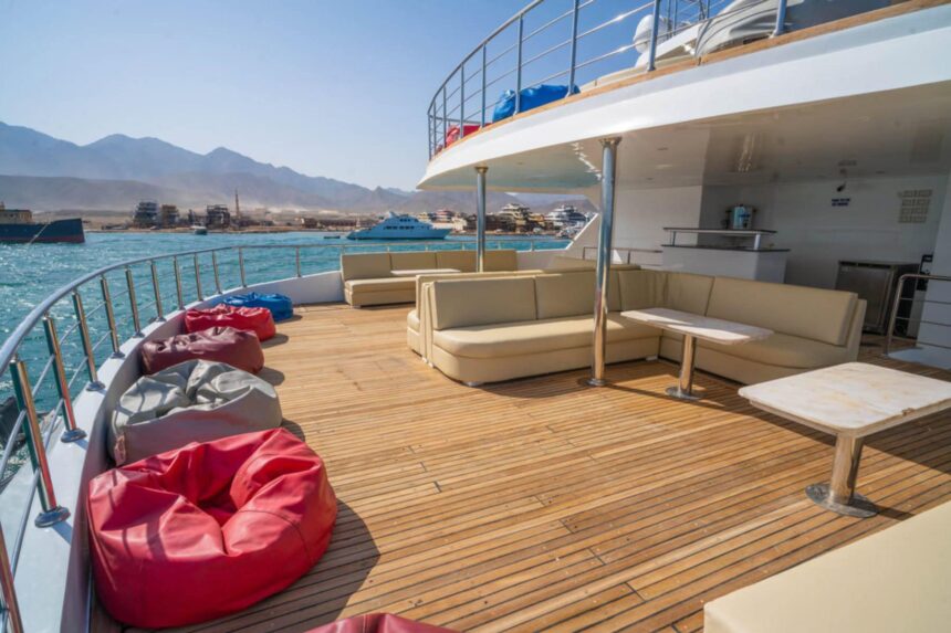 Glossy black-ceilinged lounge aboard the Hammerhead II with white curved sofas