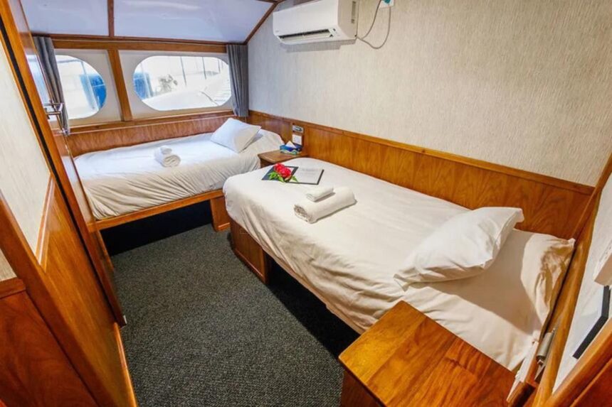 Twin bed cabin aboard MV Oceania with a curtained window