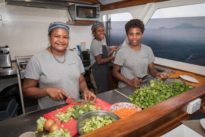 MV Oceania galley crew preparing fresh vegetables for dinner