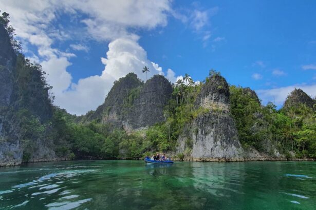 A small dive tender navigating limestone karst islands near the Indo Master