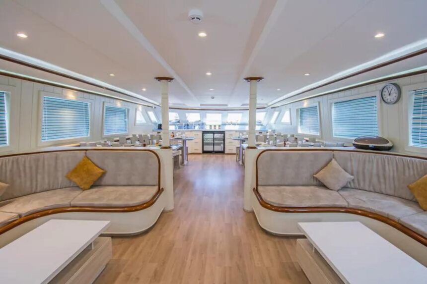 Spacious salon lounge with curved sofas and columns aboard the Sea Serpent Contessa