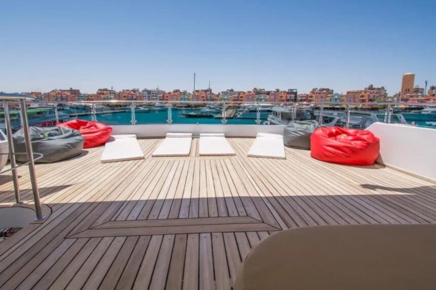 Sun deck with loungers and red beanbags overlooking a marina