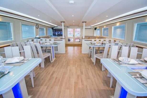 Dining room with rows of tables set for guests aboard the Sea Serpent Contessa