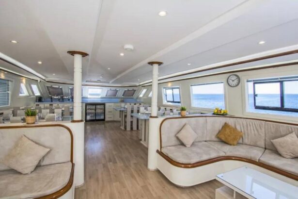 Upper deck salon with curved sofas and wood columns on the Sea Serpent Contessa