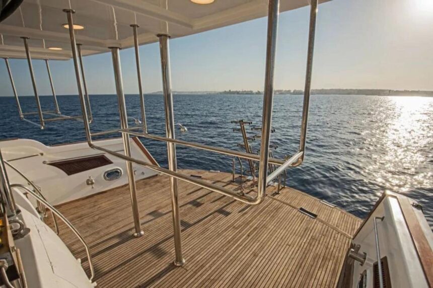 Empty stern deck with stainless steel rails at sunset on the Sea Serpent Excellence