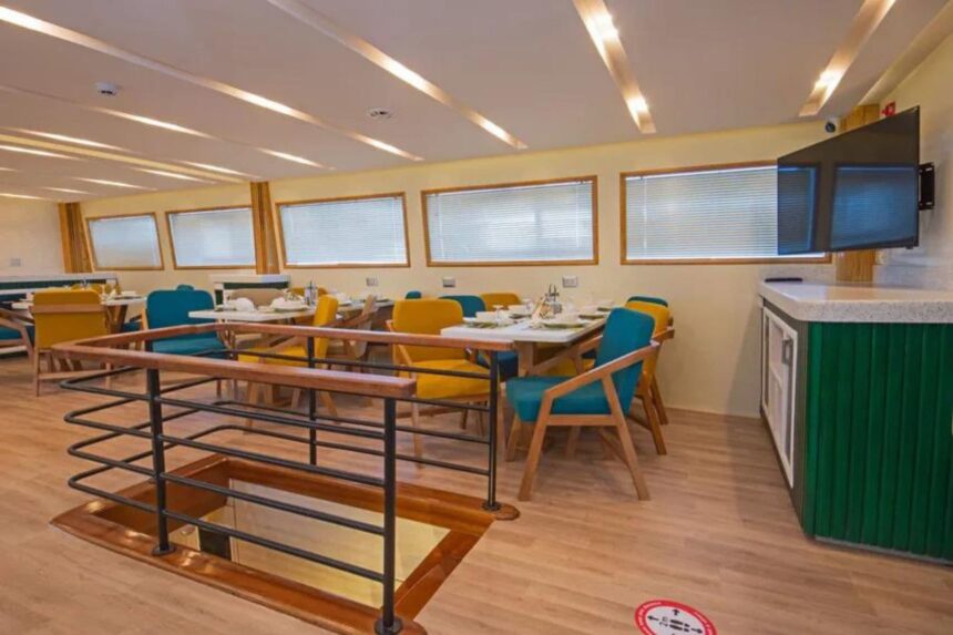 Upper deck dining lounge with yellow and teal chairs aboard the Sea Serpent Excellence