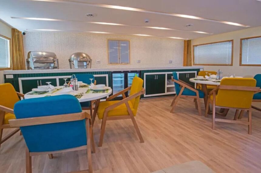 Cabin with a teal accent wall and an open ensuite bathroom door on the Sea Serpent Excellence