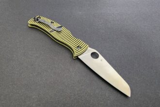 Spyderco Caribbean folding knife open, showing its sheepfoot blade and yellow and black striped handle