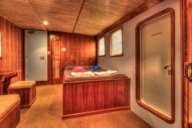 Bedroom cabin with a wooden bed and rolled towels aboard the Ocean Hunter III