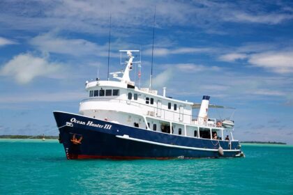 The MV Ocean Hunter III liveaboard anchored in a turquoise lagoon
