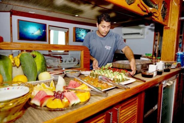 Crew member preparing a fruit and vegetable spread at the buffet counter on the Ocean Hunter III