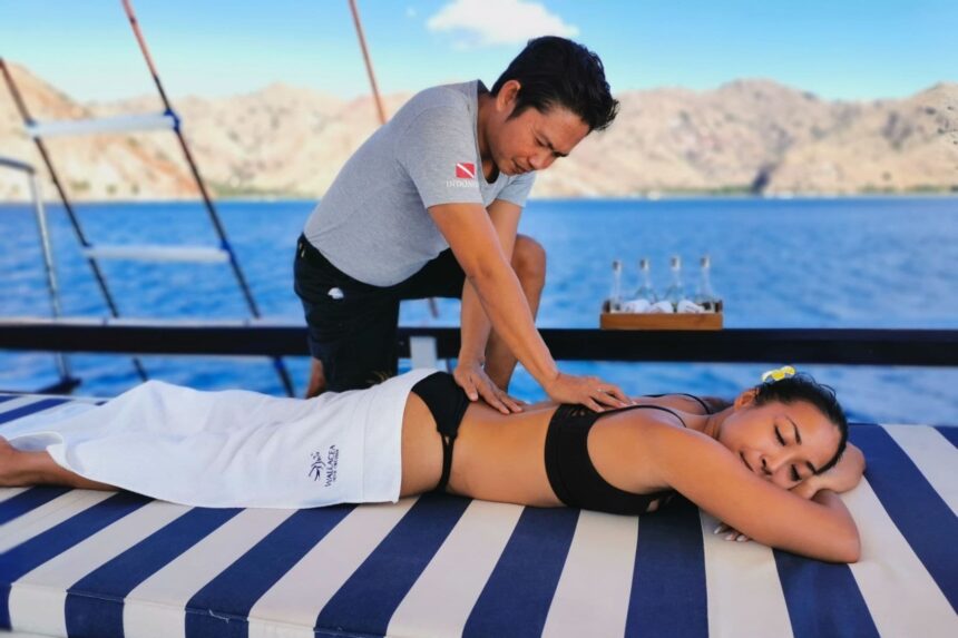 Guest receiving a massage on deck of the MSY Seahorse with mountains in the background
