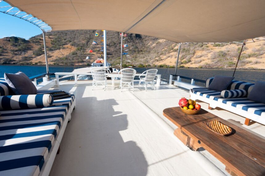 Shaded lounge deck on the MSY Seahorse with striped daybeds and a low table of fruit