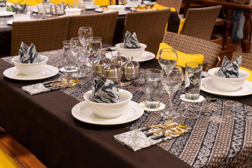 Dinner table set with white bowls, batik napkins and wine glasses aboard the MSY Seahorse