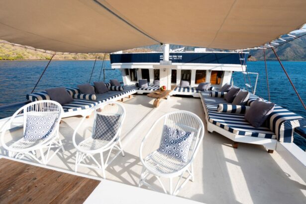 Covered lounge deck with striped daybeds and white wicker chairs under a canvas awning