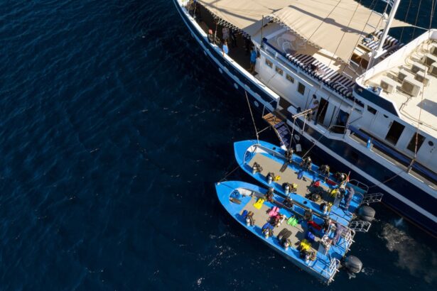 Aerial view of divers loading gear onto two tender boats alongside a liveaboard