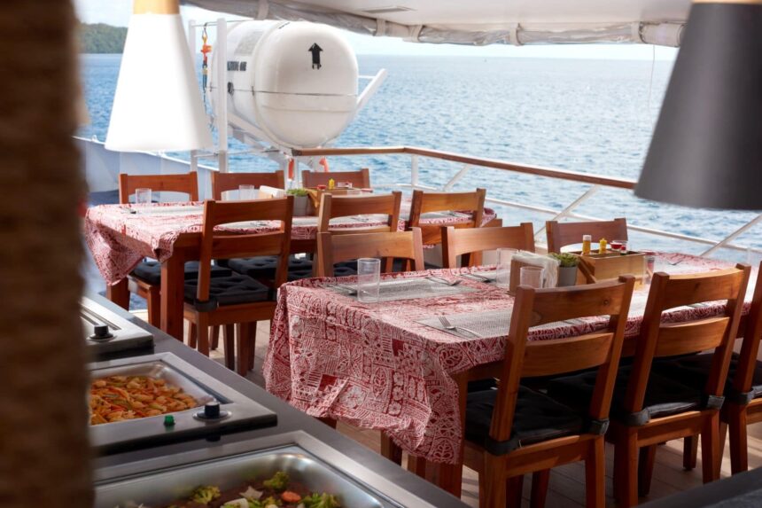 Outdoor dining tables set on the Solitude One's deck overlooking the sea