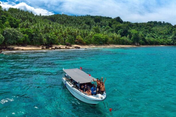 Divers giving thumbs up aboard a tender boat near a tropical shoreline