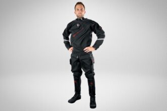 Man wearing the Hollis DX-300X black drysuit with attached boots and thigh cargo pockets