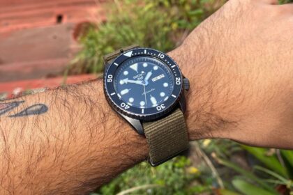 Our tester wearing the Seiko 5 Sports SRPD91 with its navy dial on an olive nylon strap outdoors
