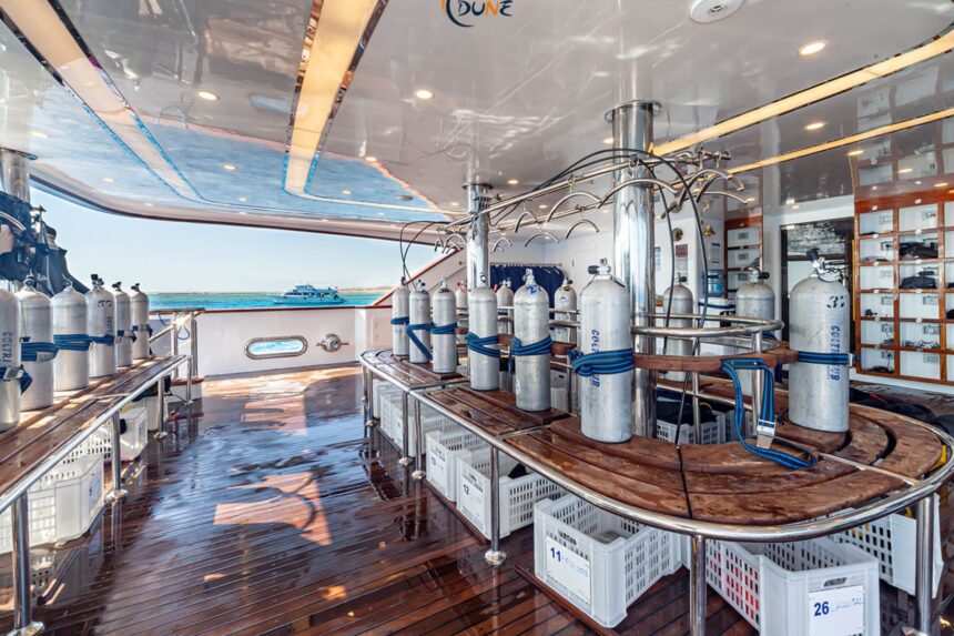 Scuba tanks racked on the dive deck of the Alia liveaboard