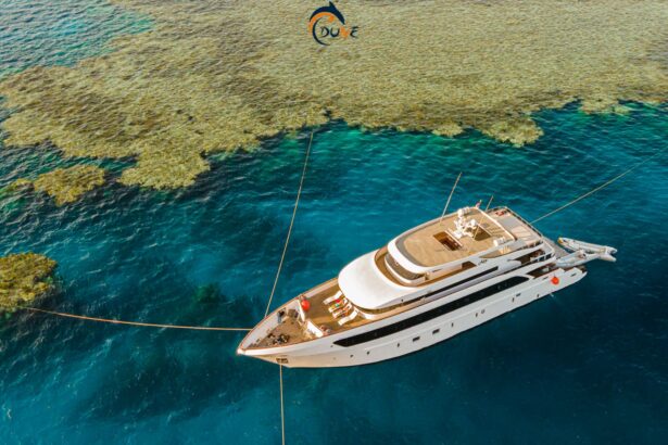 Aerial view of the Alia liveaboard anchored beside a shallow coral reef