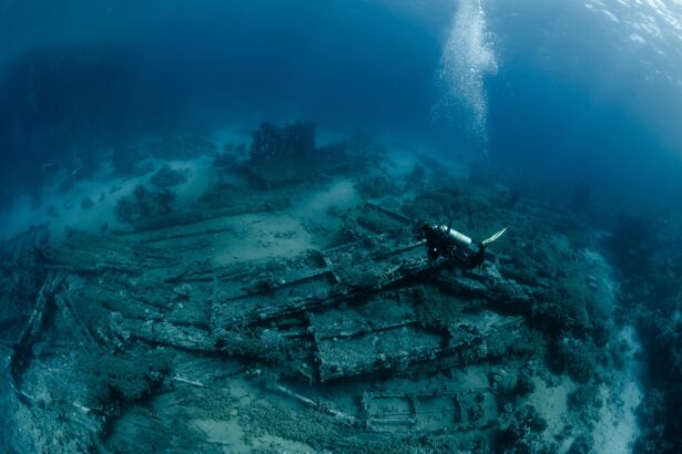 Diver descending onto a large sunken shipwreck