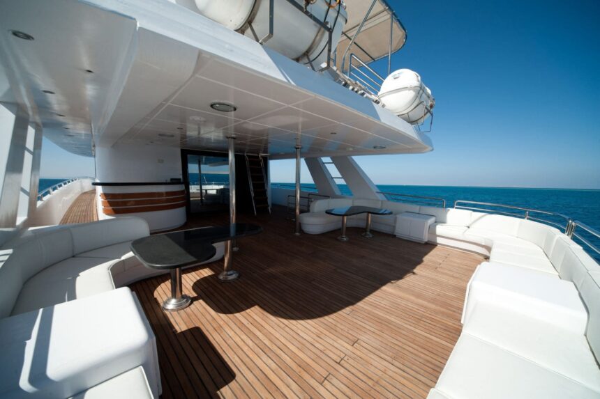 Shaded lounge deck aboard the Betel Gueser with white cushioned seating