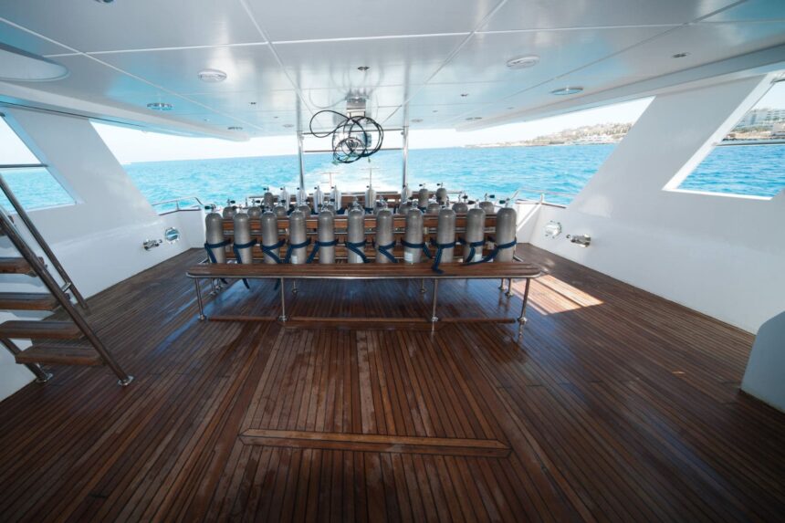 Scuba tanks lined up on the Betelgueser's wooden dive deck