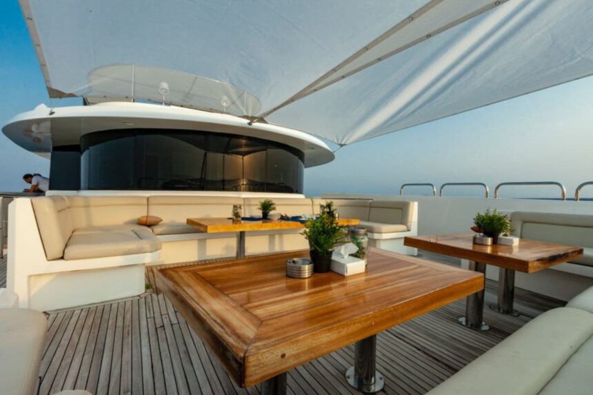 Shaded sundeck seating with wooden tables on the MY Blue