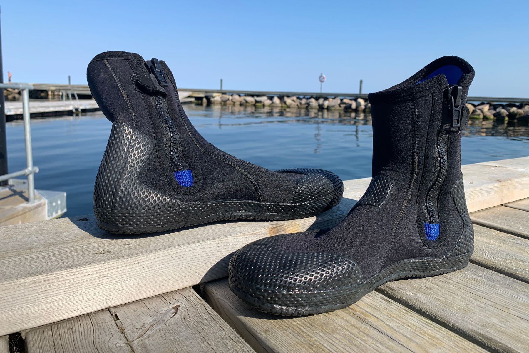 Aqua Lung Superzip dive boots with front zippers and blue lining on a dock by the harbour