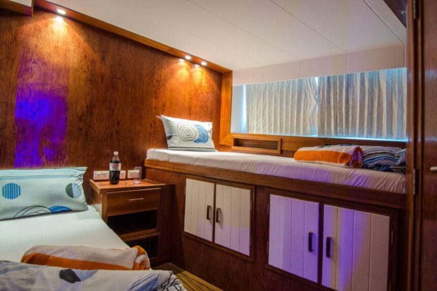 Wood paneled cabin with bunk beds aboard the MY Blue Planet 1