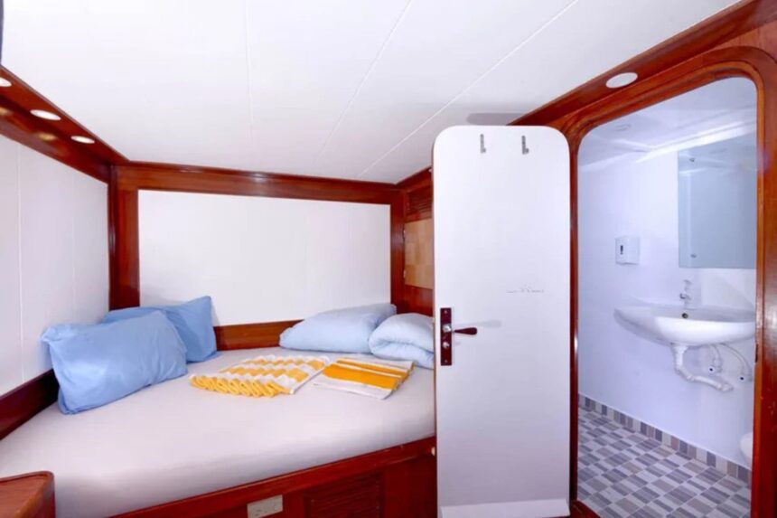 Cabin bunk bed with wood trim and ensuite bathroom on the MY Blue Pearl