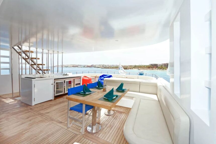 Outdoor dining table set with teal napkins on the MY Blue Pearl aft deck