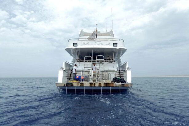 Stern view of the MY Blue Pearl liveaboard with crew on the swim platform