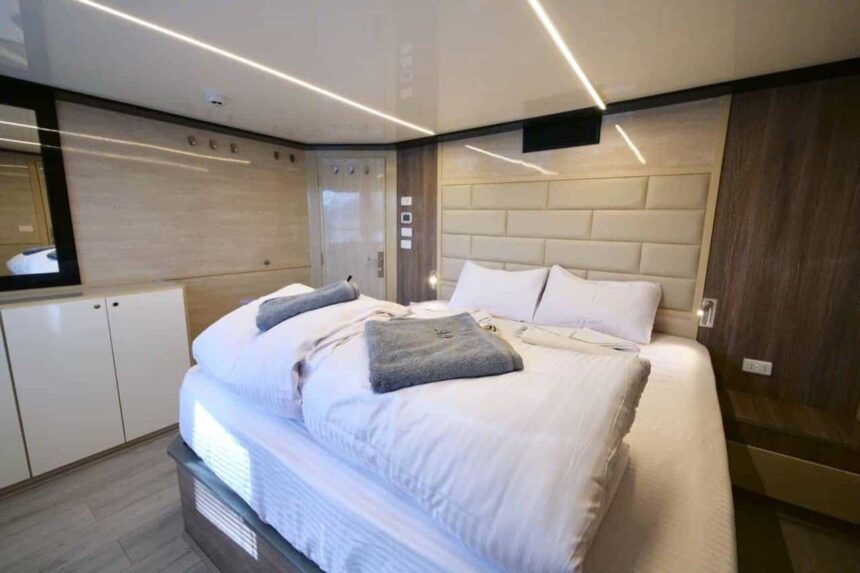 Modern double bed suite with reading lights aboard the MY Blue Storm