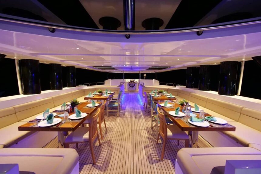 Dining salon lit in purple at night aboard the MY Blue Storm