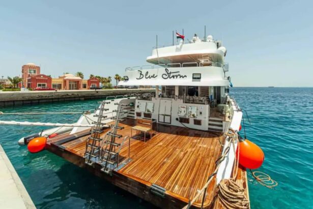 MY Blue Storm liveaboard moored stern-to at a dock with its teak dive deck and orange fenders