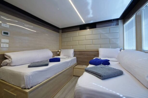 Twin-bed cabin aboard MY Blue Storm with folded towels and a padded headboard