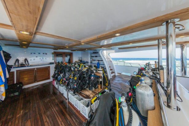 Rows of scuba tanks and BCDs set up on the dive deck of MY Blue Seas
