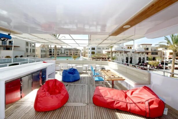 Shaded lounge deck with red and blue bean bags overlooking a resort town shoreline