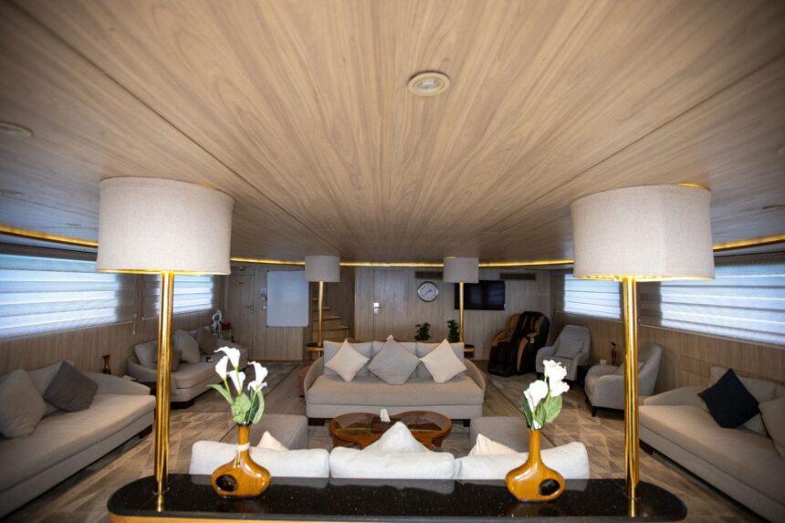 Wood-paneled lounge with sofas, armchairs and floor lamps aboard the Captain Sparrow
